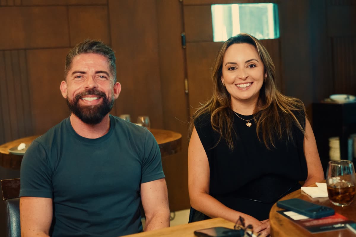 Dupla de participantes sorrindo à mesa