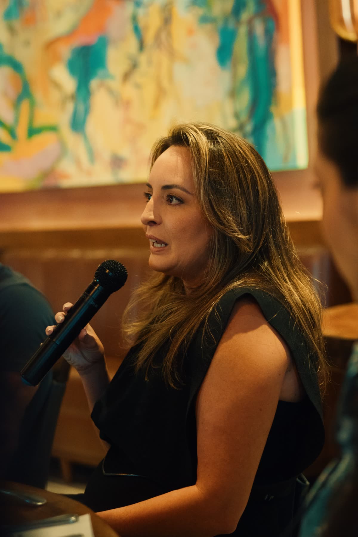 Empresária falando ao microfone durante o encontro